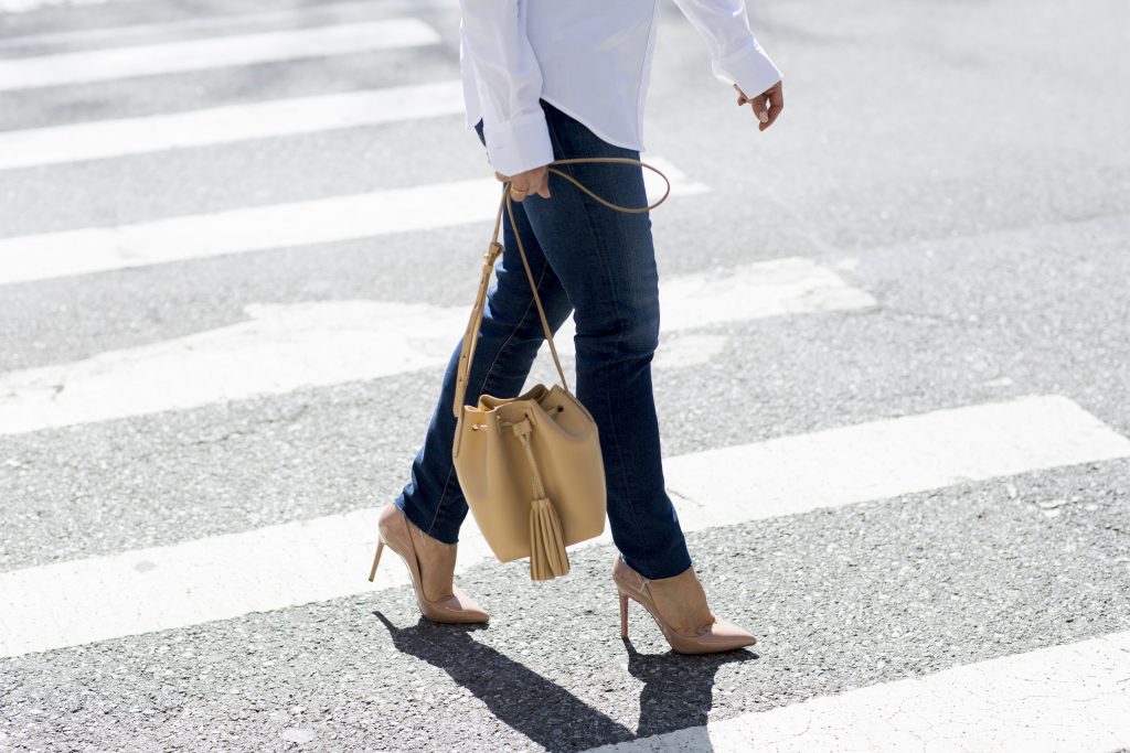 the corporate catwalk wearing a white button down shirt and denim with high heels in new york city for a casual weekend look 